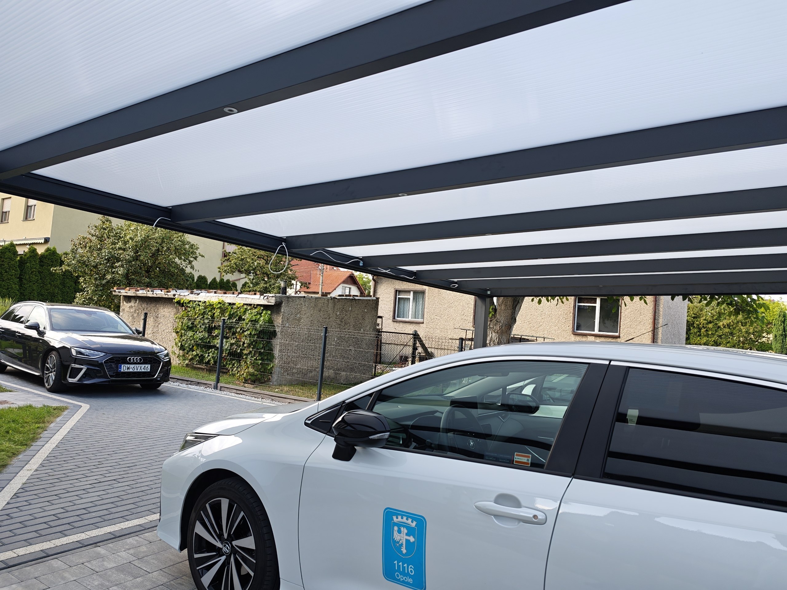 Blick von unten auf das Carport-Dach aus hellem Polycarbonat und Aluminiumträgern