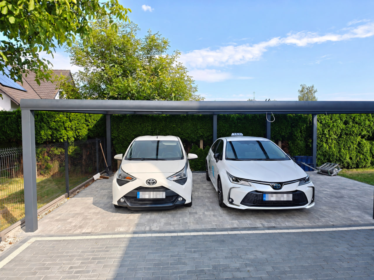 Vorderansicht eines Carports für zwei Autos mit einem Dach aus Polycarbonat