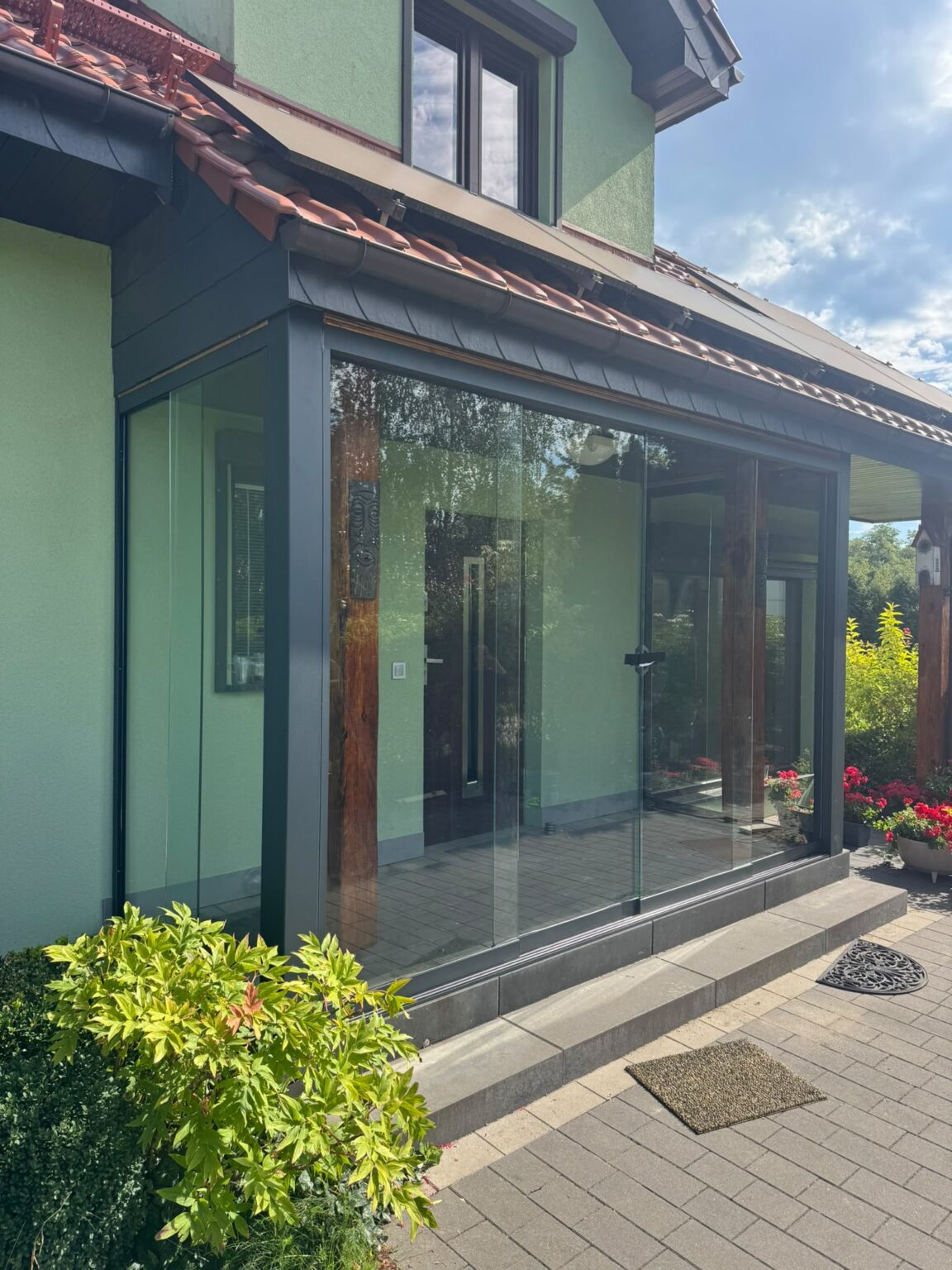 Et moderne vindfang i glass ved inngangen til huset